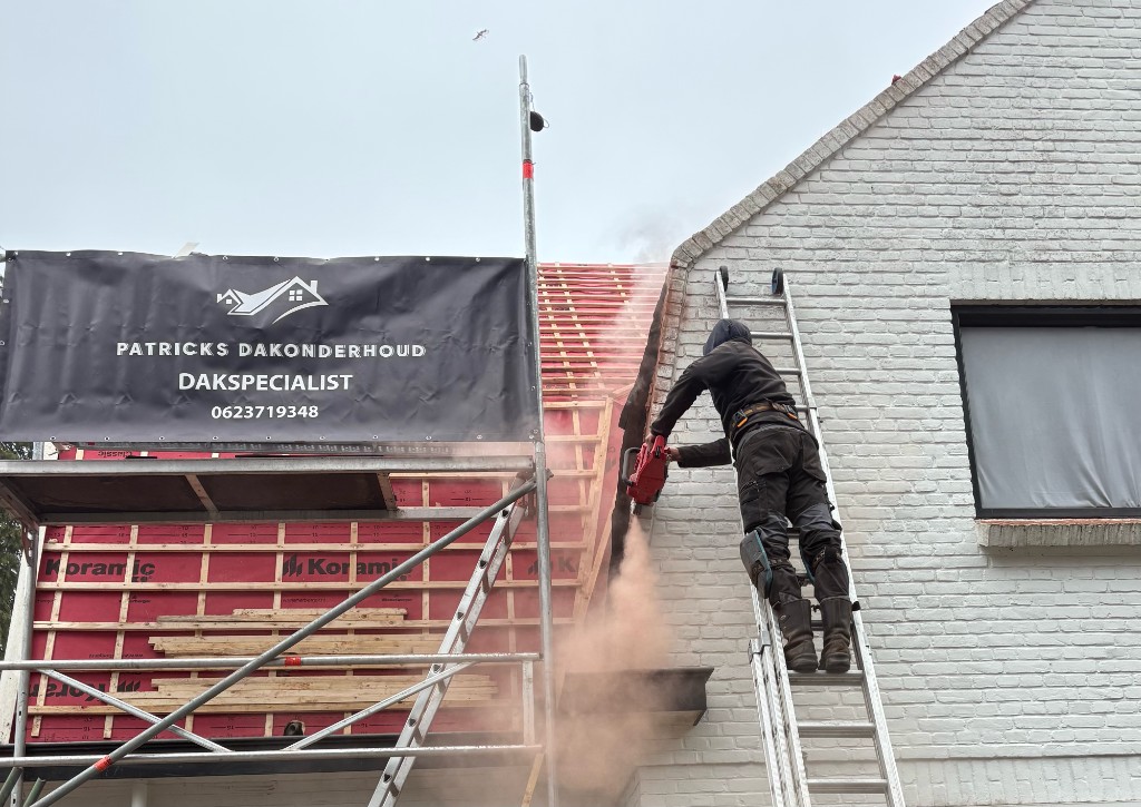 Dakdekker van Patrick's Dakonderhoud aan het werk op een dakrenovatie met bedrijfsbanner